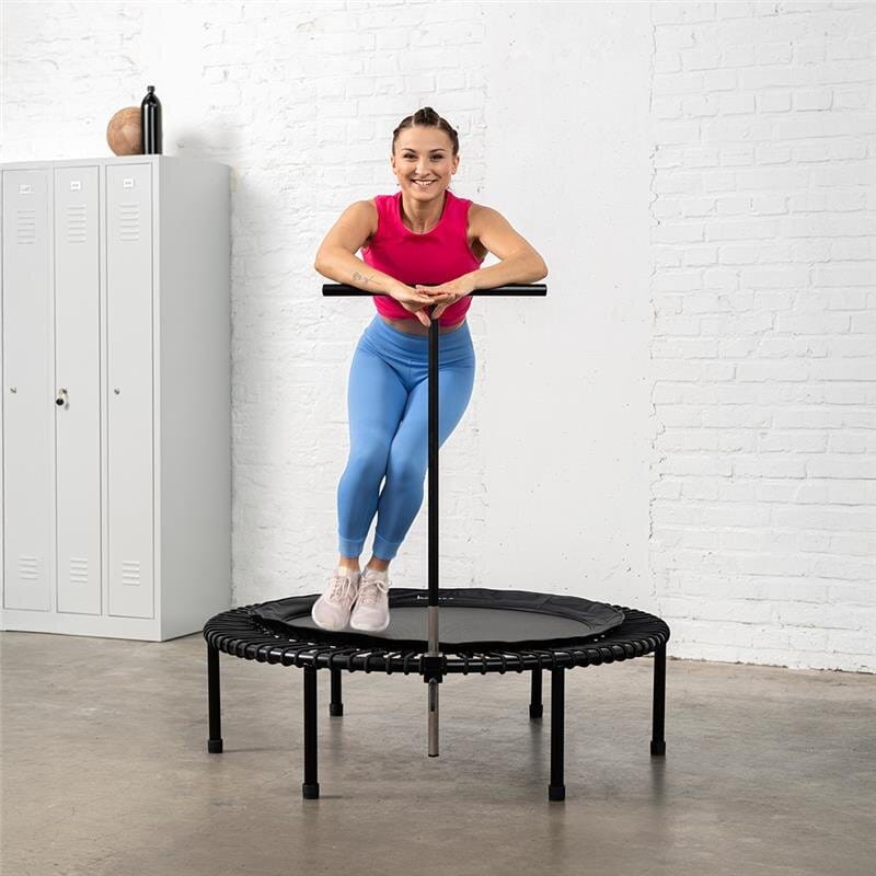 Eine Frau macht ein Cardio-Workout auf dem bellicon Mini-Trampolin mit T-Bar.