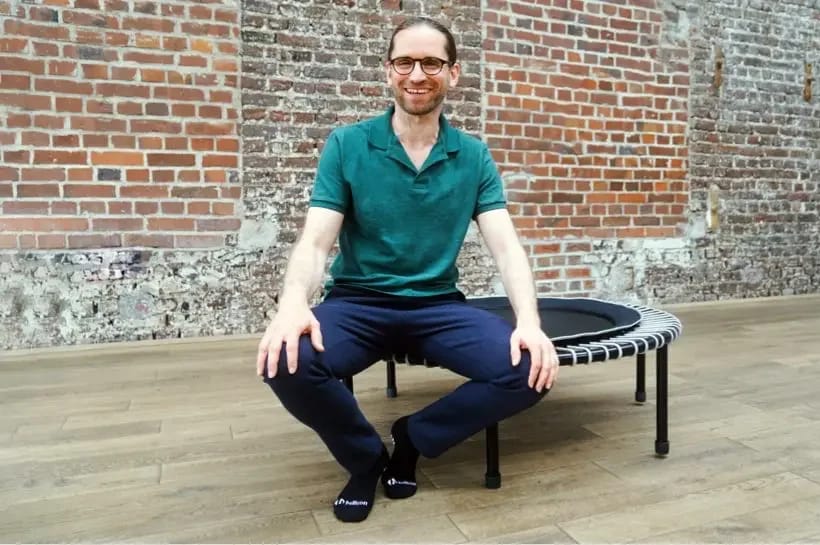 Axel Heil is sitting on the bellicon mini-trampoline.