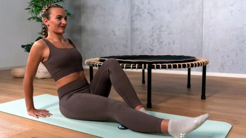 Woman is triggering her calves with the bellicon TMX trigger.