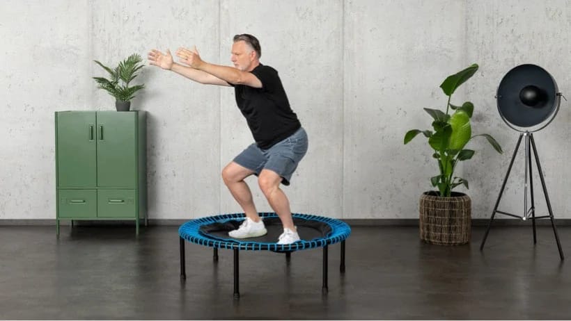 Mann macht Kniebeuge auf dem bellicon Trampolin