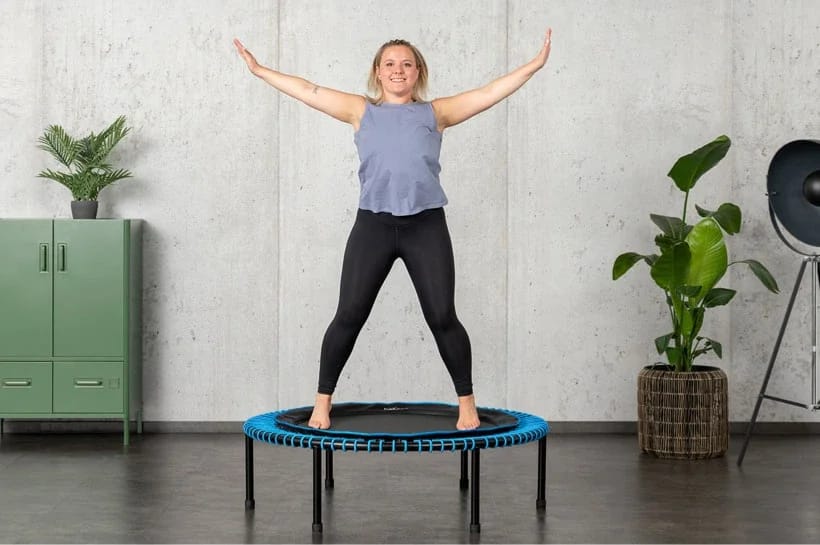 Une femme saute avec bonheur sur un mini-trampoline bellicon.