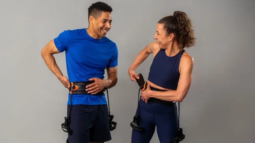 A man and a woman are wearing the Shadowboxer belt and laughing.