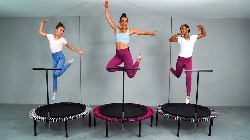 Zusammen mit zwei Kindern springt eine bellicon Trainerin auf dem Trampolin.