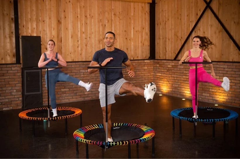 Trois personnes s'entraînent ensemble sur des mini-trampolines.