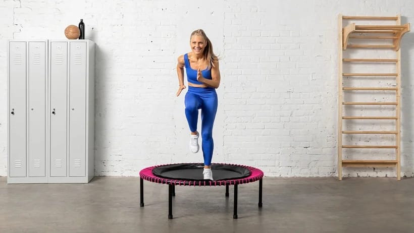Young woman is doing an intense cadio workout on the bellicon rebounder.